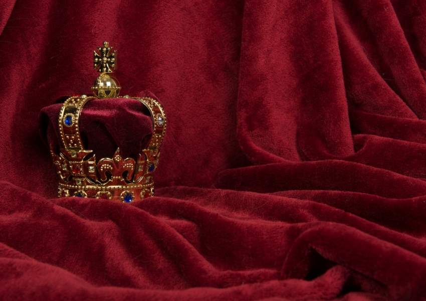 A picture of a crown on a red velvet cloth