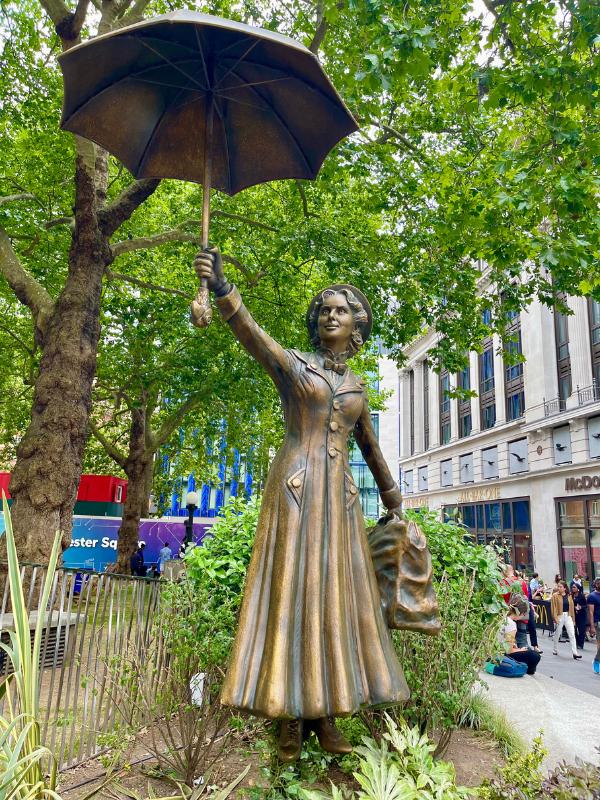 statue of a lady holding an umbrella.