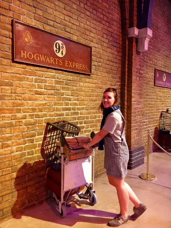 A picture of a girl pushing a trolley into a wall at King's Cross Station