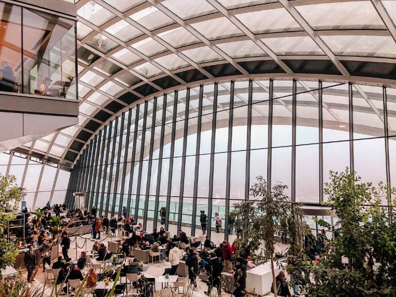 A glass wall with a view of London from the Sky Garden a London bucket list choice for many visitors