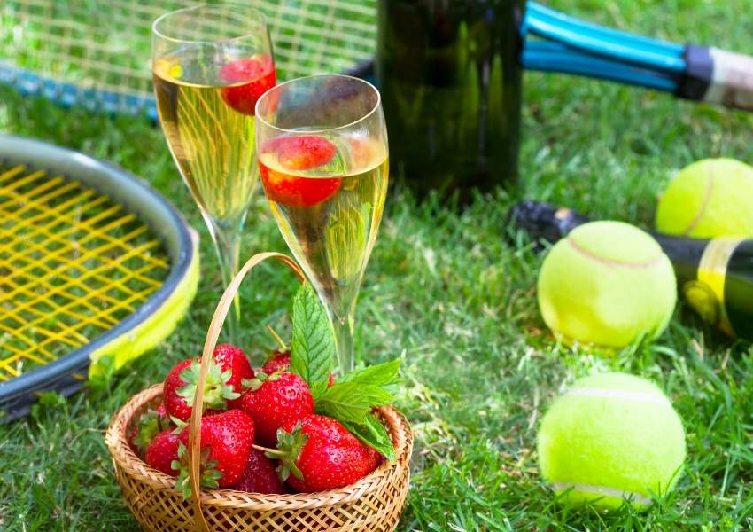 A tennis racquet, strawberries and some champagne glasses 