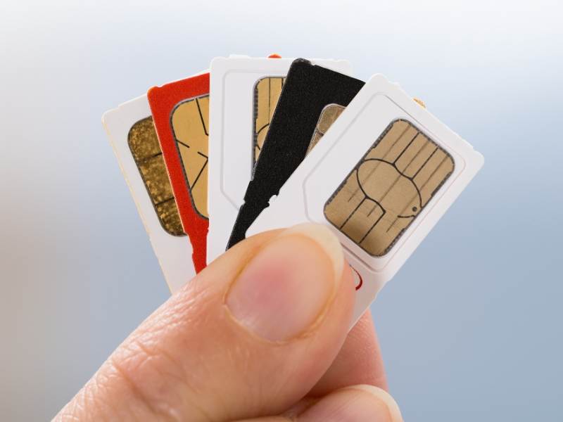 A person holding a selection of the best UK sim card for visitors 