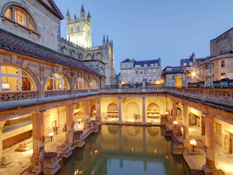 An image of the Roman Baths lit up in the evening