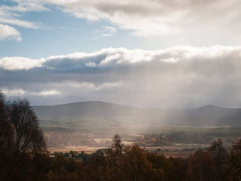 A valley with sun rays shining through the clouds