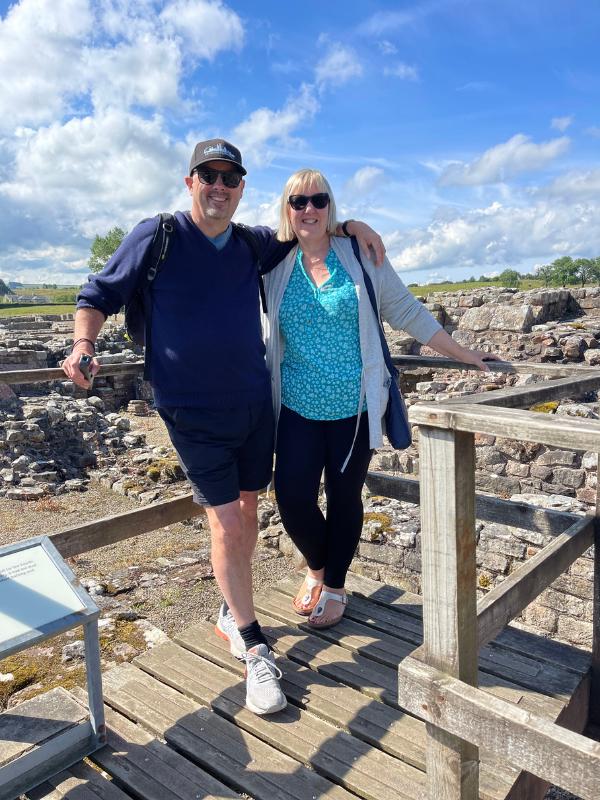 A man and a lady standing near some ruins.