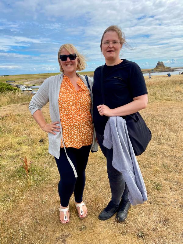 Two ladies standing in front of a castle.