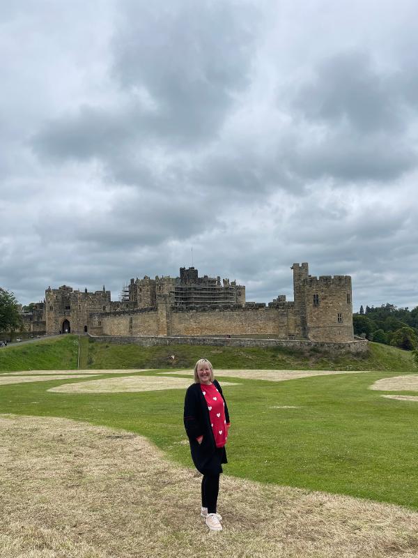 A lady standing in front of a castle.
