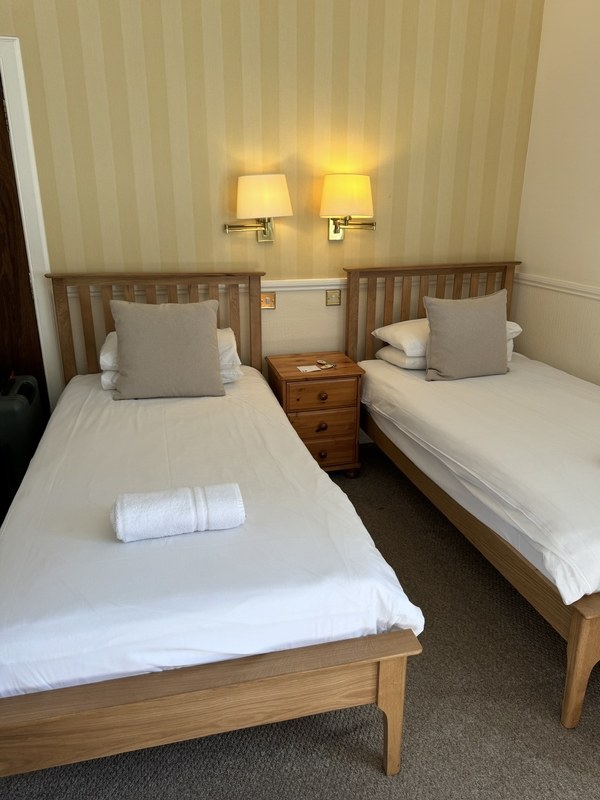 A twin room at Elder York Guest House in Edinburgh with two single beds and brass wall lights