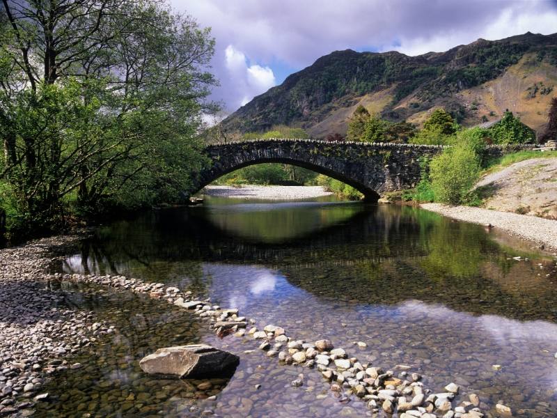 A bridge over a stream in Grange in Borrowdale one of 24 pretty towns and villages in the Lake District to visit