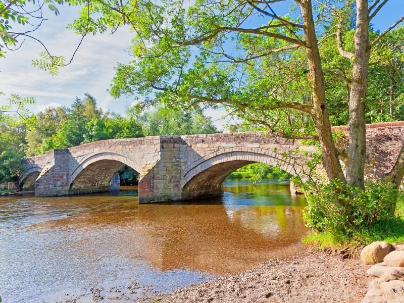 A bridge over a stream in Pooley Bridge one of 24 pretty towns and villages in the Lake District to visit