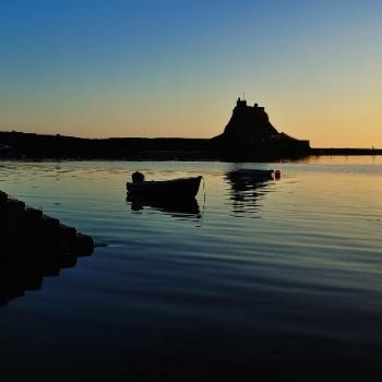 A silhouetted image of Lindisfarne Island which is a top place to visit in any England Regional Guide 