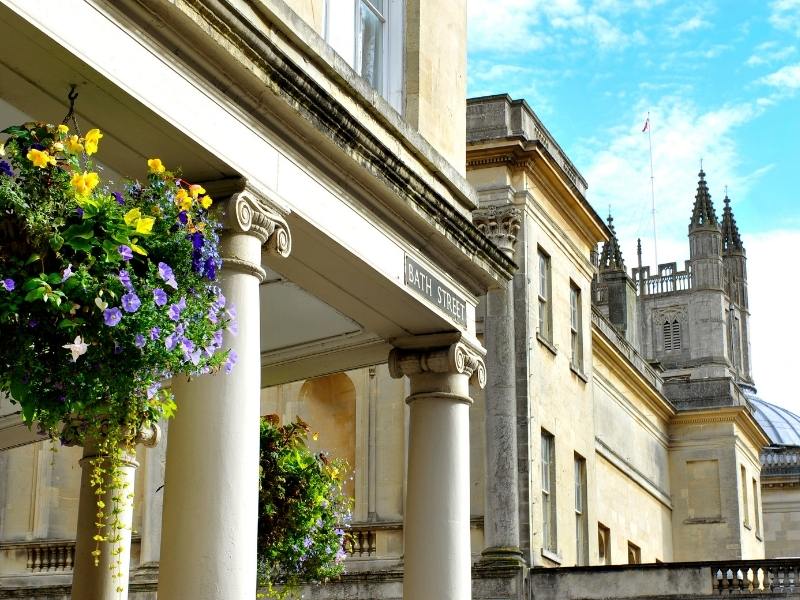 Bath Abbey in the background with hanging baskets a must see in any Bath travel guide