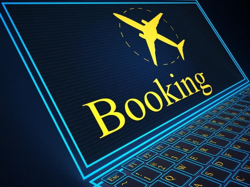 A computer with a booking sign and an airplane