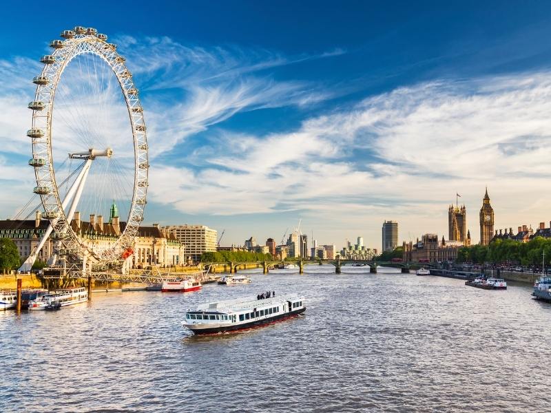 The London Eye, a boat on the river Thames and Big Ben in the background.