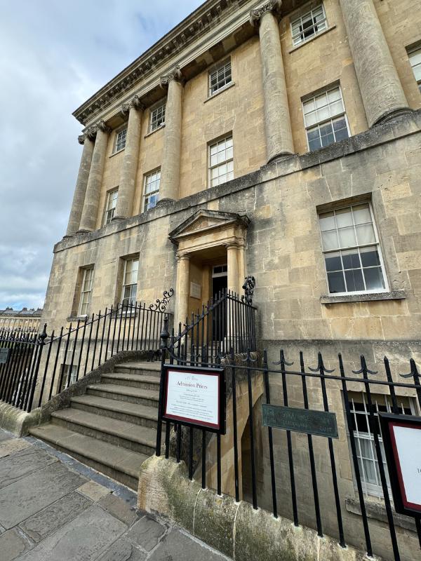 a stone building with a gate and a sign