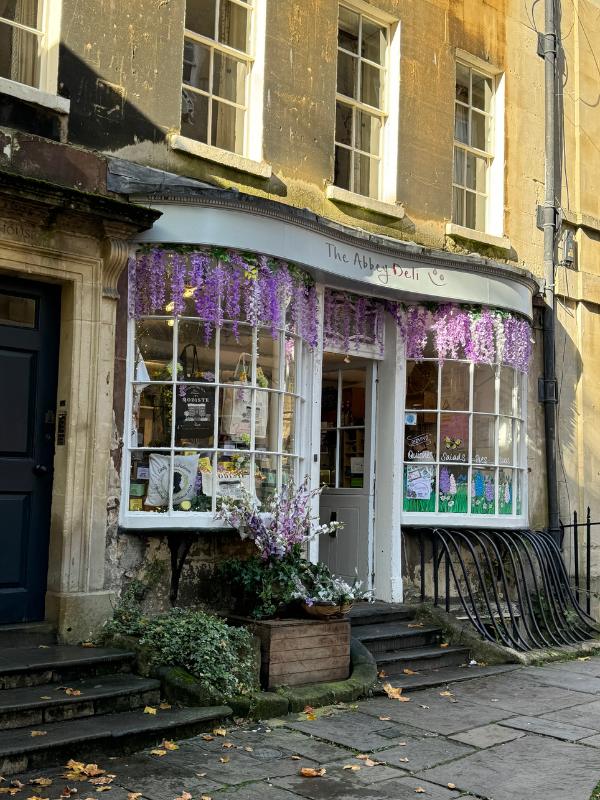 a store front with flowers on the front