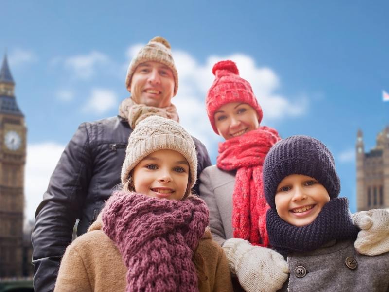 A family visiting London England and posing in front of Big Ben found one of the Best London hotels for families for their stay