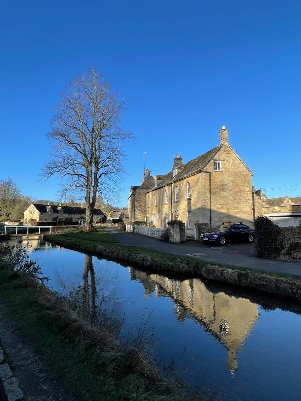 A stream with houses and a blue sky.