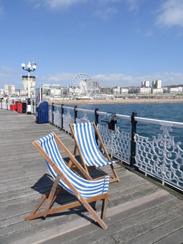 Brighton pier with 2 deckchairs.