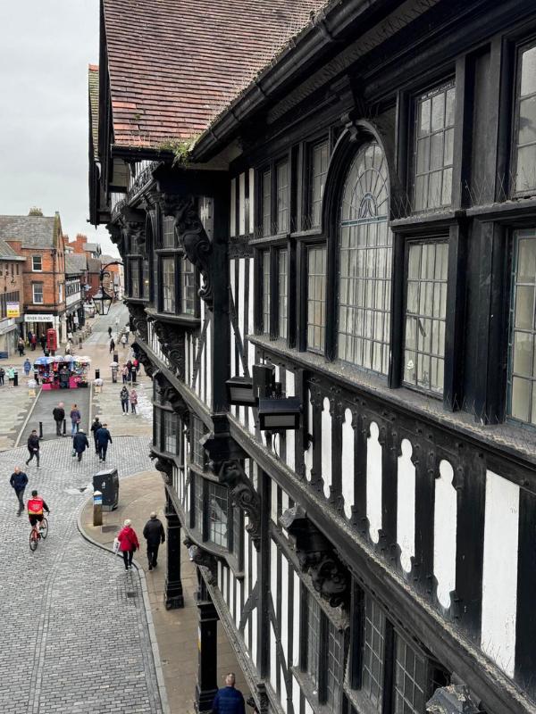 a building with many windows and people walking on the street