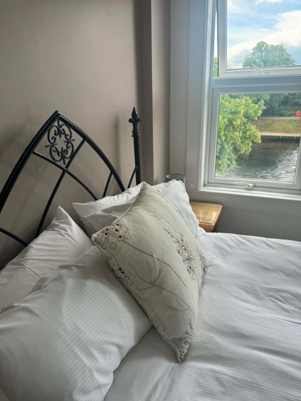Bed beside a window looking out over the River Ouse at Abbey Guest House York