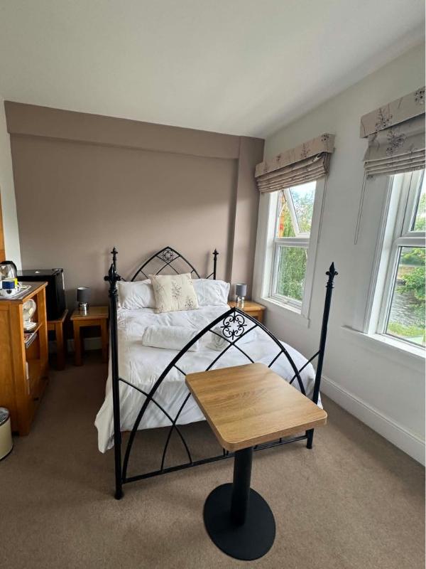 Double room with iron four poster bed and river facing windows at Abbey Guest House York