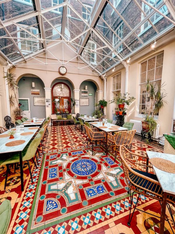 Glass roofed atrium café with Victorian tiled floor at the Bar Convent, York