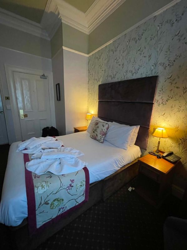 Traditionally decorated bedroom with floral wallpaper at The Minster Hotel, York