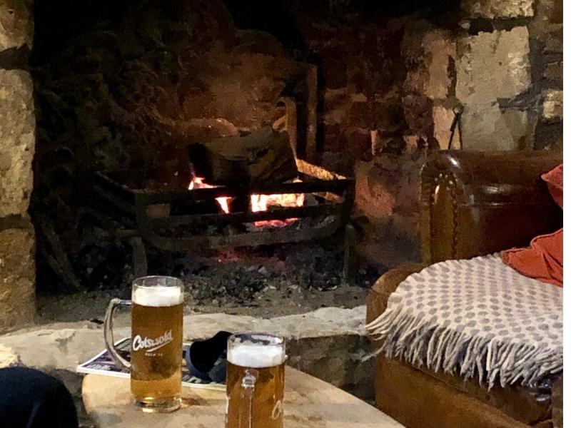 Open fire with 2 glasses of beer in a pub.