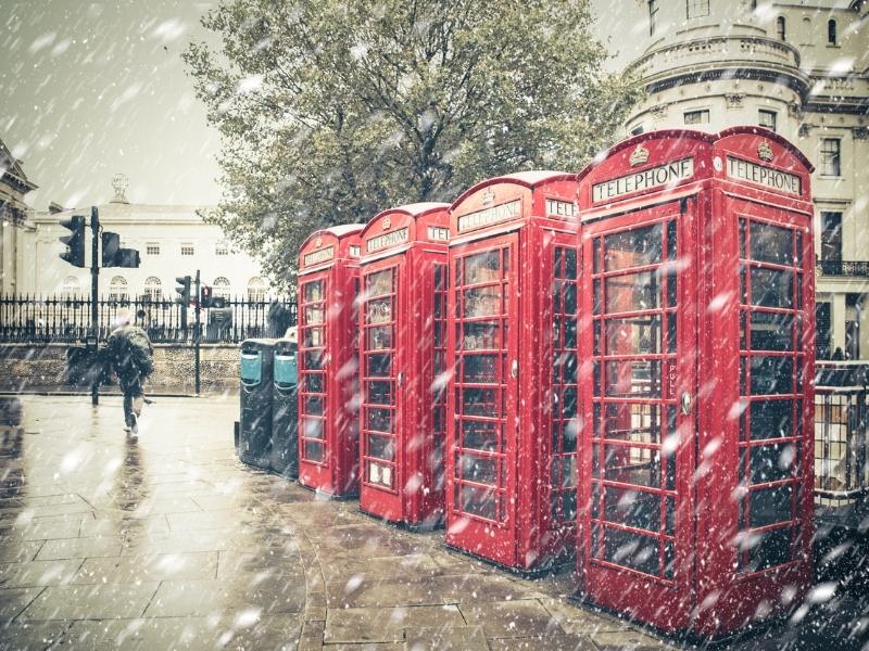 Red phone boxes in a blizzard.