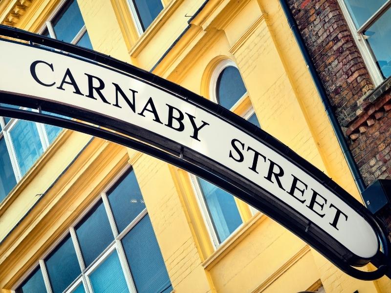 Sign for Carnaby Street and hotels near Leicester Square in London.