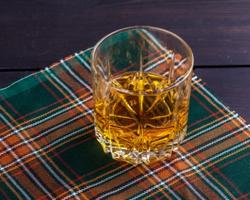 Scotch whisky glass on a tartan table cloth.
