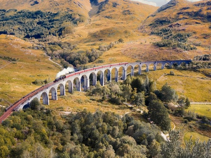 The Harry Potter train in Scotland (the Jacobite) crosses the Glenfinnan viaduct.
