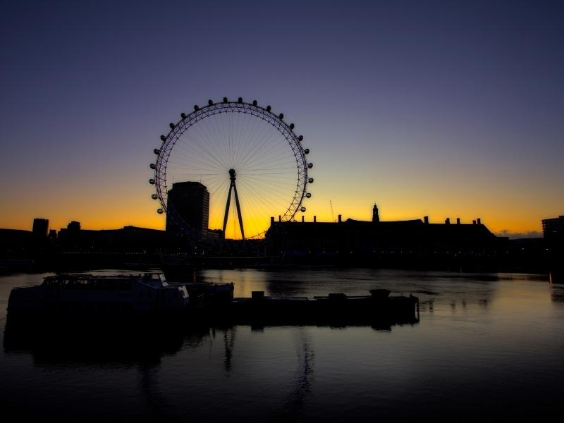 THe London Eye silhouetted against the London sky at sunset.