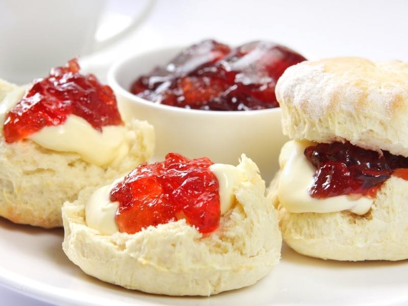 A plate of scones with jam.