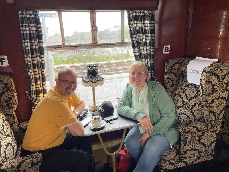 Man and woman sitting on a train in first class.