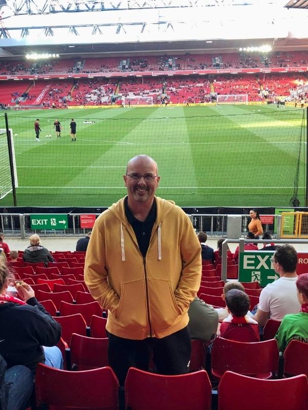 A man standing at Anfield Football ground.