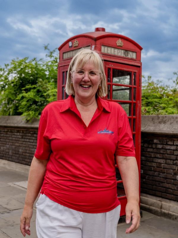 Woman in front of a red phone booth in London.