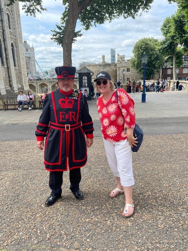Lady standing next to a London Beefeater.