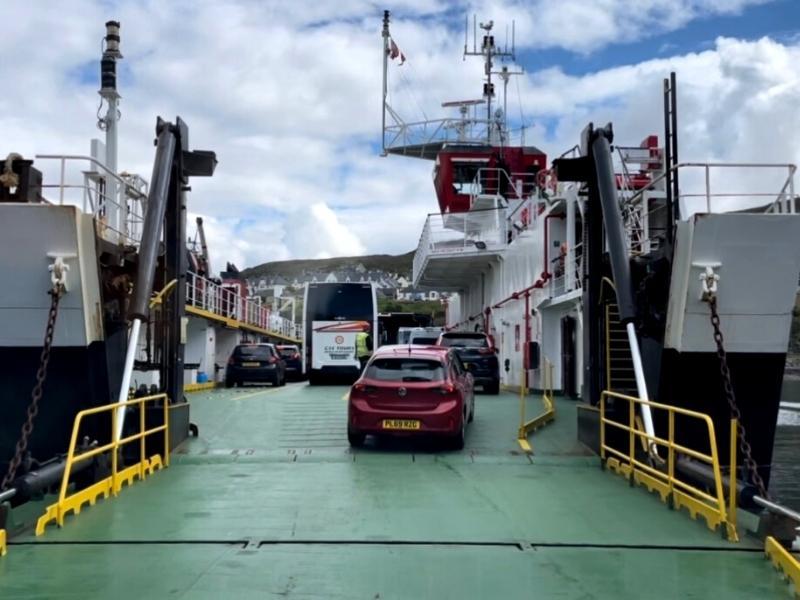 Cars driving onto a ferry.