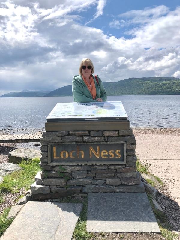 Woman standing in front of a sign which. read Loch Ness