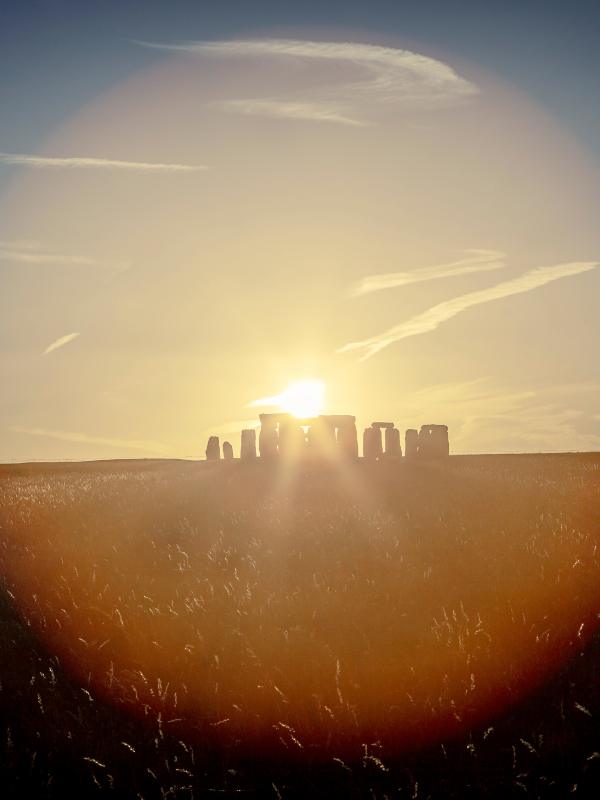 Stonehenge with the sunlight behind it.