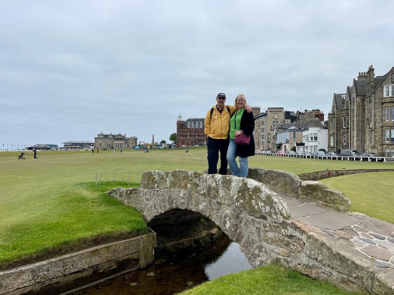 St Andrews travel guide image of two people standing on the Swilcan Bridge at the Old Course in St Andrews.