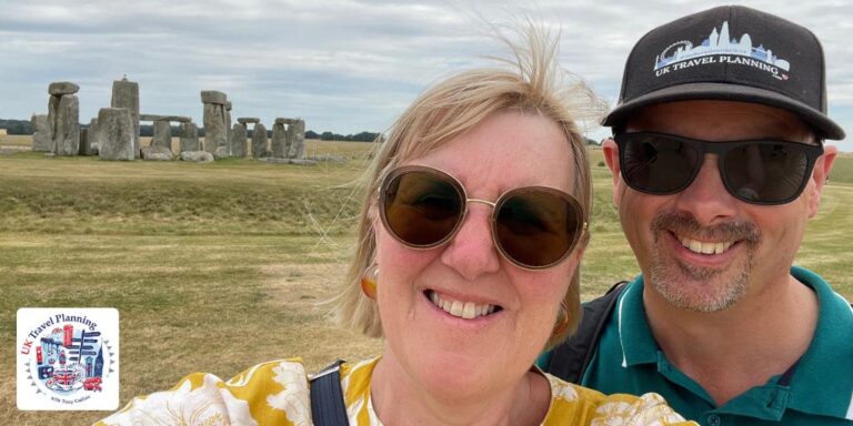 A man and a lady stand in front of Stonehenge.
