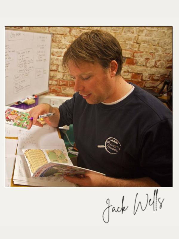 Jack Wells, creador de Mystery Guides, trabajando en un nuevo libro de aventuras en su escritorio.