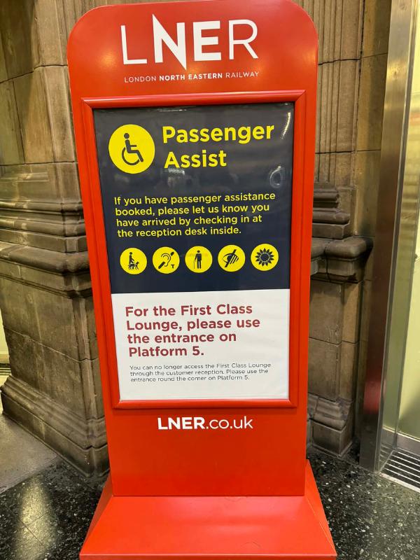 LNER Passenger Assist sign at a UK train station showing accessibility services including guide dogs, hearing loops, mobility assistance and Hidden Disabilities Sunflower scheme