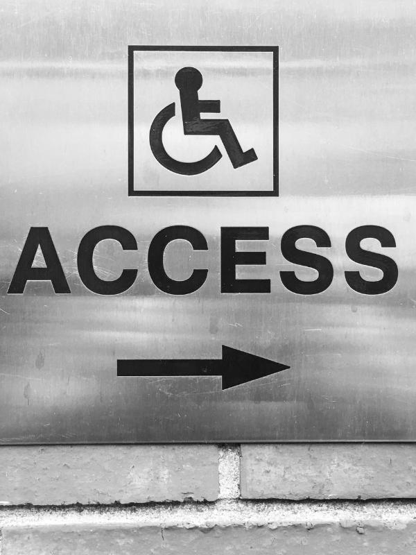 Accessible travel UK — wheelchair access sign with directional arrow at a UK venue.