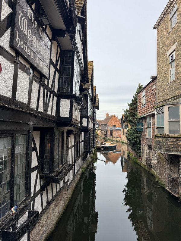 The historic Canterbury canal and timber-framed buildings on an English Bus day tour from London