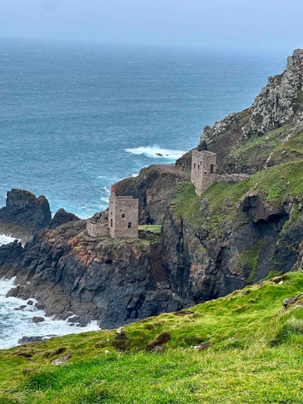 The ruined Botallack tin mine engine houses perched on the cliffs above a stormy sea