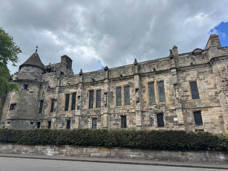 The stone front of Falkland Palace, with its round corner tower and carved figures between the windows